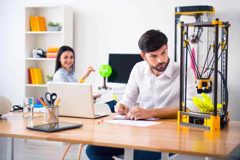 Man printing 3D model, happy woman watching him.